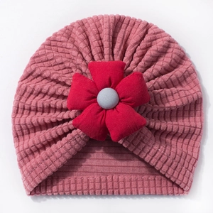 Detail of baby turban hat with waffle texture fabric and a large fabric flower decor