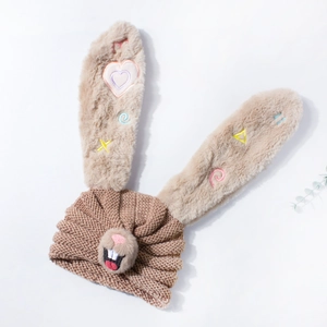 Detail of warm baby knit hat with brown bunny ears and colorful heart embroidery