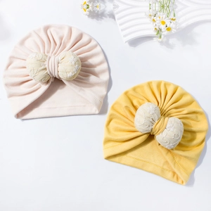 Close-up of baby turbans with decorative floral lace embroidery on large 3D bows