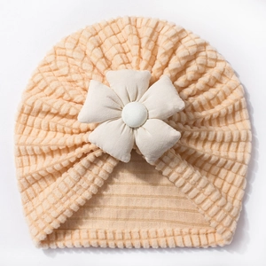Detailed close-up of baby turban hat featuring waffle knit fabric and a large fabric flower
