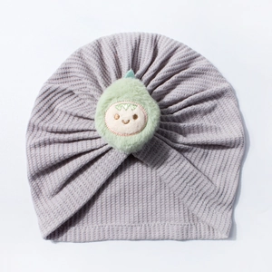 Detail of baby waffle knit hat in light purple with a cute plush avocado doll decoration