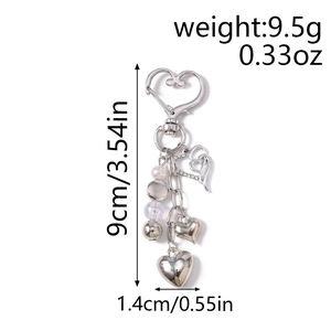 Vue détaillée du porte-clés coeur argenté avec strass et perles montrant 9cm de long