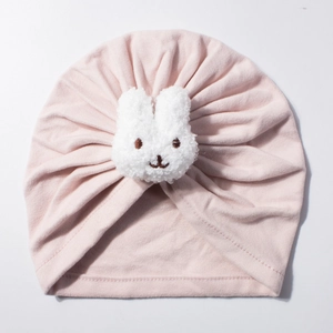 Close-up of pink baby turban hat featuring a cute white plush bunny patch detail