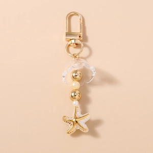 Gros plan détaillé d'un pendentif étoile de mer dorée avec perles et cloche transparente