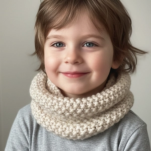 Close-up of cream knit snood for kids showing thick textured pattern and soft material