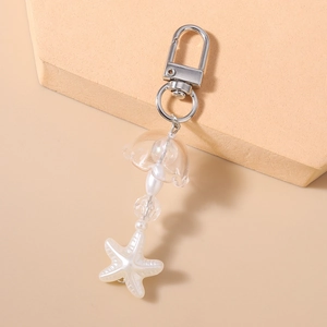 Détail d'un porte-clés étoile de mer perlé avec perles blanches et perle florale