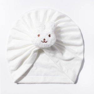 Detail of baby white pleated beanie featuring a cute plush bunny embroidery