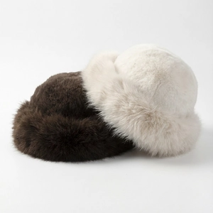 Close-up of fluffy faux fur winter hats in dark brown and creamy white colors