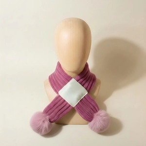 Rose pink knitted baby cross scarf with soft pompom decor on a wooden mannequin