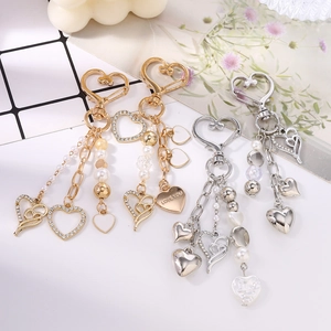 Porte-clés cœur élégant avec perles et strass sur un fond décoratif esthétique