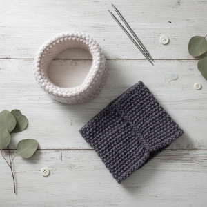 Handmade chunky knit baby snoods in beige and grey on a rustic wooden background