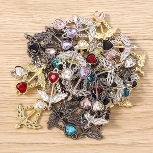 Detailed macro view of heart crystal Cupid arrow charms with gold and silver metal frames