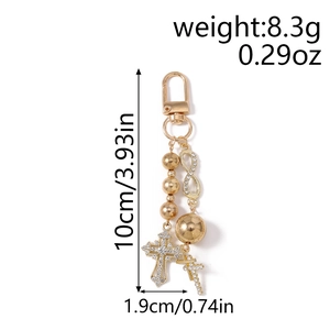 Detail of gold beaded keychain with rhinestone infinity symbol and cross pendant