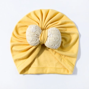 Infant yellow pullover hat featuring a large embroidered beige bow for autumn and winter