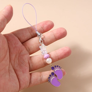 Detail of purple paw-shaped phone charm with star beads and enamel foot pendants