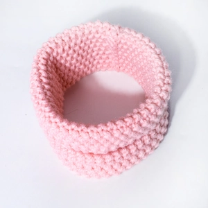 Close-up of pink chunky knit baby neck warmer showing thick textured woven pattern