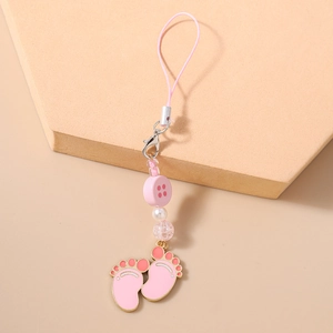 Close-up of pink paw print charms and beaded mobile strap on minimalist display board