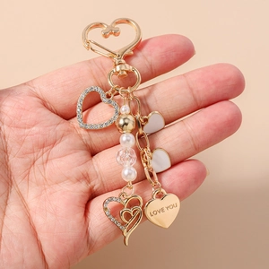 Vue détaillée d'un porte-clés en forme de cœur avec alliage doré, strass et perles