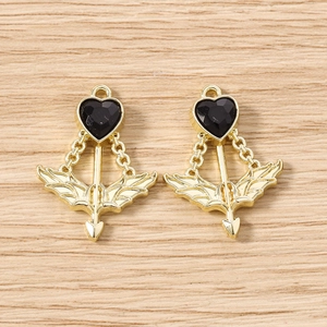 Detail showing gold cupid heart arrow charms with black stones for jewelry making