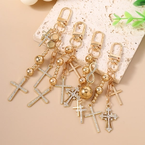 Golden beaded keychains with rhinestone cross pendants and lobster clasps for bags