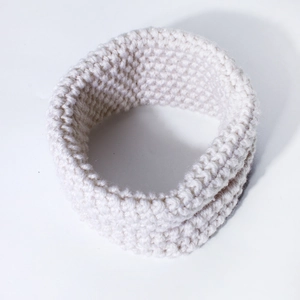 Detailed view of the soft beige knitted winter neck warmer with rich texture