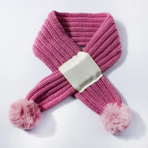 Detailed knit texture of rose pink baby scarf with soft pom-pom and fabric patch detail