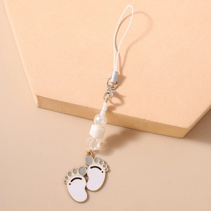 Detail of beaded phone charm with white paw print pendants and gold metal edges
