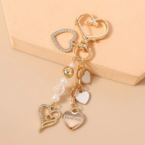 Détail du porte-clés cœur doré avec gravure Love You et perles sur support