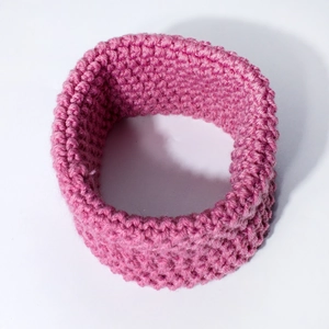 Detailed view of magenta knitted neck warmer with thick ribbed yarn texture for winter