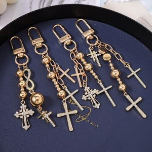 Macro shot of gold-plated cross keychains with crystal rhinestones on a display pad