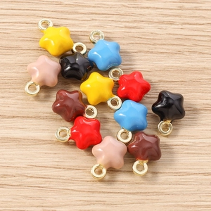 Pendentifs étoiles colorés pour bijoux DIY avec anneaux dorés sur fond de bois clair
