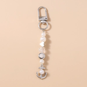Détail du porte-clés avec perles, breloques en forme de cœur et un pendentif d'ancre marine