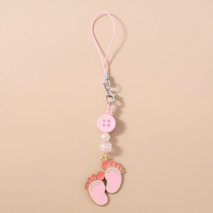 Detail of pink paw print charm with beads and metal lobster clasp on soft background