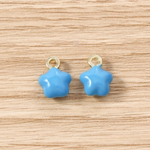 Détail macro de deux breloques étoiles bleu clair avec boucles dorées pour bijoux DIY