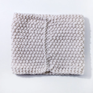 Close-up of cream white chunky knit texture on warm winter infinity scarf for babies
