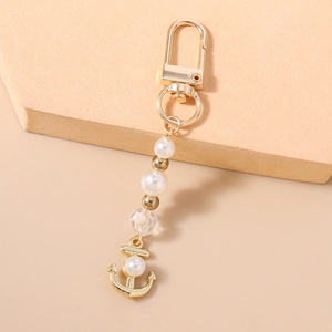 Détail du porte-clés ancre dorée avec perles nacrées et perle en cristal facettée