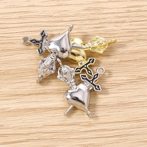 Détail macro de breloques cœur et vajra en métal or et argent pour bijoux DIY