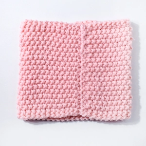 Close-up of pink chunky knit baby neck warmer showing soft texture and elastic weave