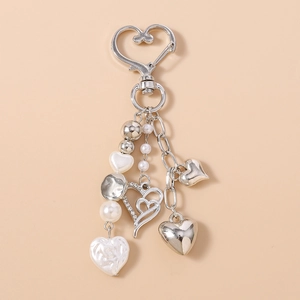 Détail du porte-clés coeur argenté avec strass brillants et perles blanches