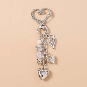 Détail d'un porte-clés coeur argenté avec strass brillants et rangée de perles colorées