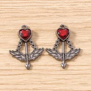 Detail of cupid arrow charms with red heart crystals and wings for DIY jewelry