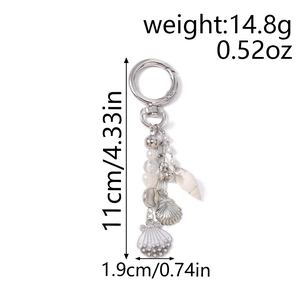 Detail of ocean-themed keychain with pearls, metal beads, and white sea shell pendants