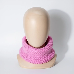 Pink knit baby neck warmer with thick ribbed texture shown on a wooden model head