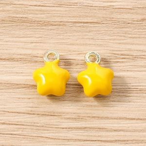Vue macro de pendentifs étoiles jaune vif avec anneaux de suspension en métal doré