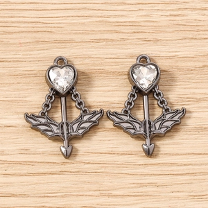 Macro shot of Cupid's arrow heart pendants with black plating and clear zircon stone
