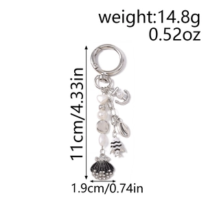 Detail of nautical keychain featuring silver anchor shell and fish charms with pearls