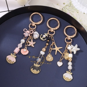Ocean-themed gold charms keychain with pearls, shells, and starfish for bags