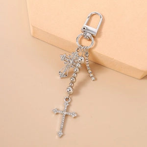 Detail of silver beaded keychain with sparkling rhinestone cross pendants and metal clasp