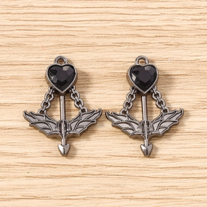 Detailed view of dark gothic heart and arrow wing pendants in gun black alloy finish