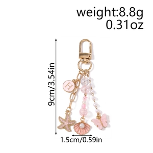 Détails des pendentifs étoile de mer, coquillage et papillon roses sur le porte-clés